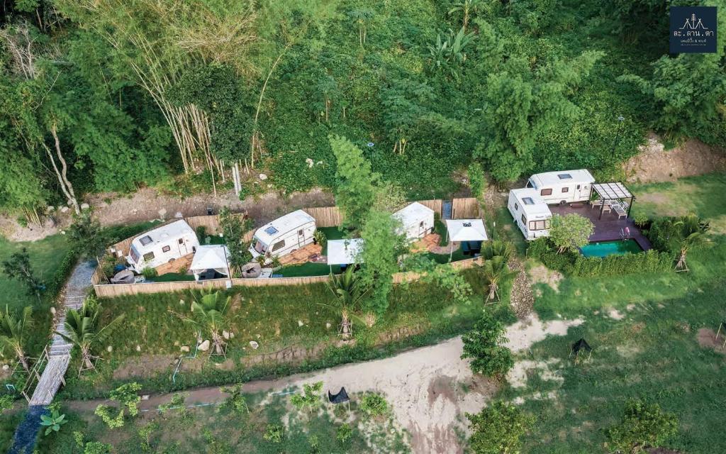 an aerial view of a group of homes with a river at ละลานตา แคมป์ปิ้ง แอนด์ คาเฟ่ in Ban Cha-om