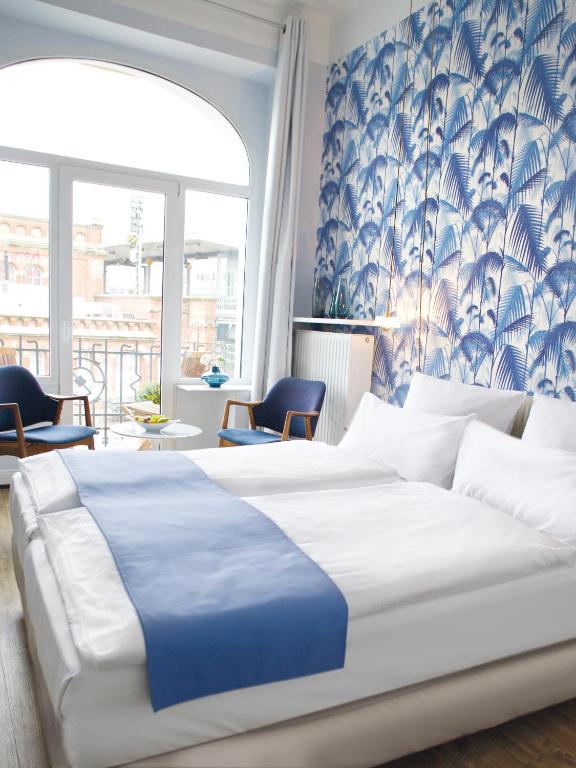 a bedroom with a large bed with blue and white sheets at Fritz im Pyjama in Hamburg