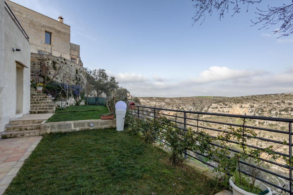 a building with a fence next to a field at L'Antica Conceria in Matera