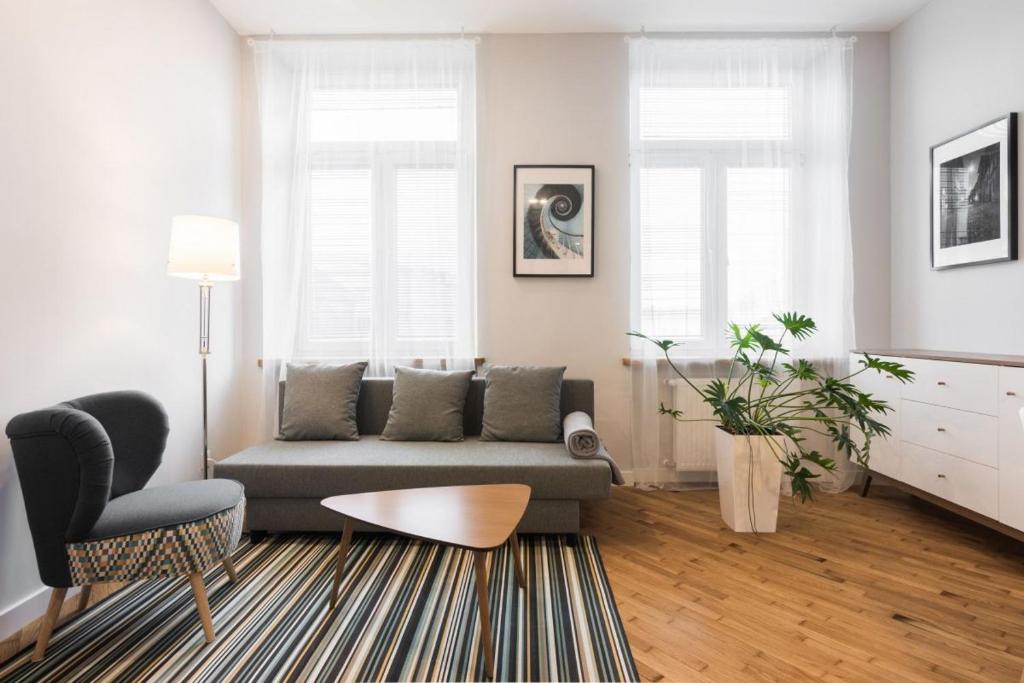 ein Wohnzimmer mit einem Sofa und einem Stuhl in der Unterkunft Luxury Apartments Nearto Main Square in Krakau