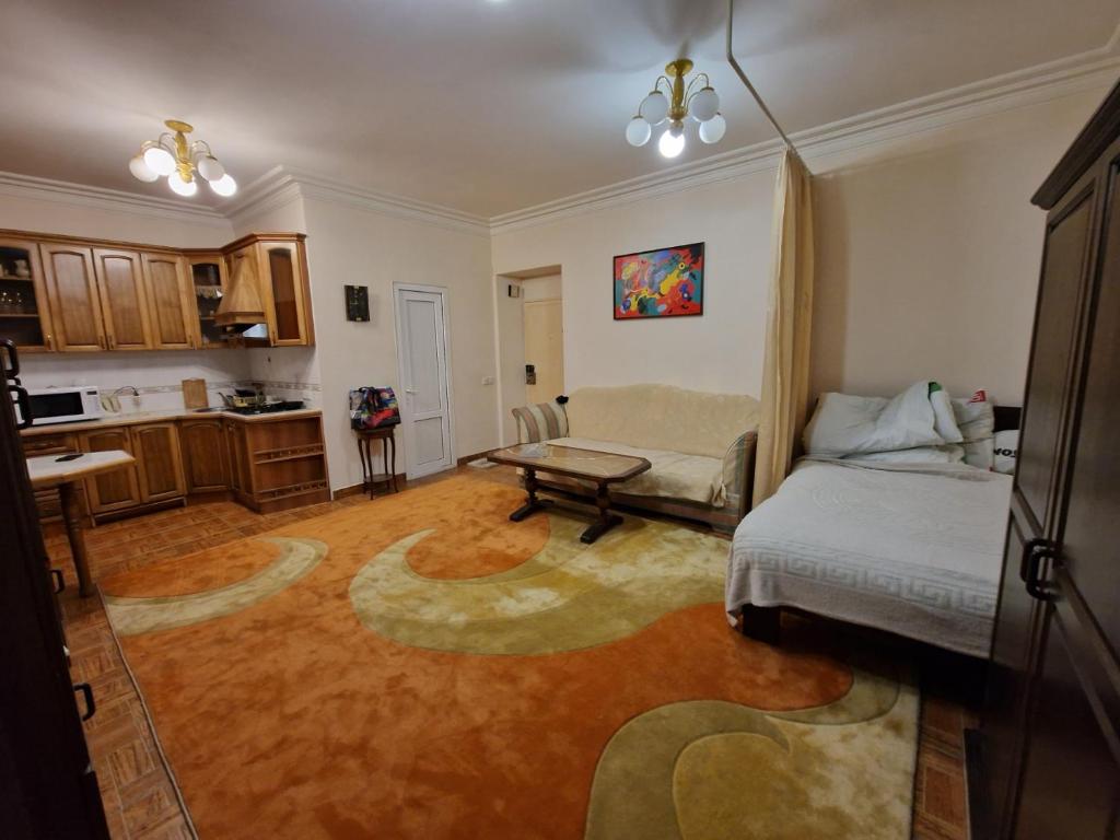 a living room with a bed and a table at Saryan Street Studio Apartment in Yerevan