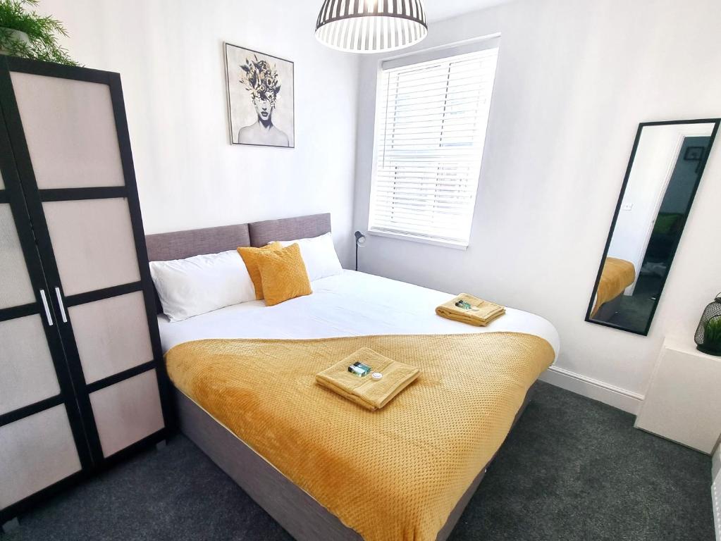una camera da letto con un letto con due scarpe sopra di STYLISH 2 Bed APARTMENT WITH FREE PARKING, WIFI a Colchester