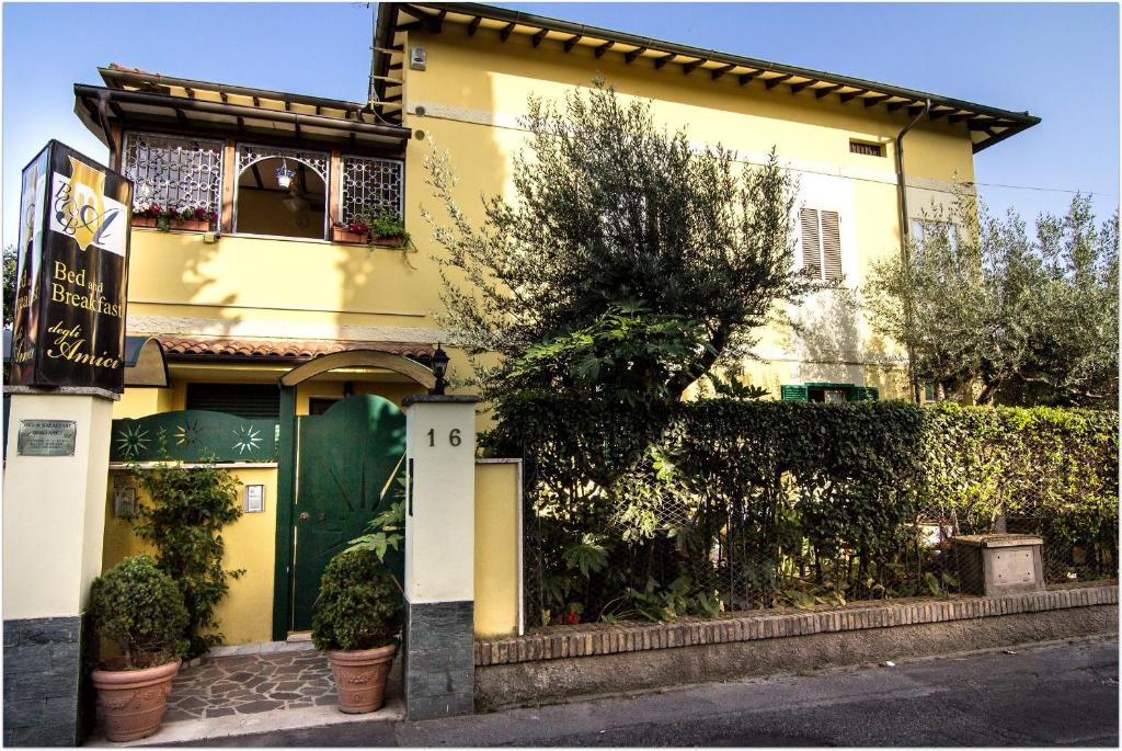 Una casa amarilla con plantas delante. en B&B Degli Amici, en Ciampino
