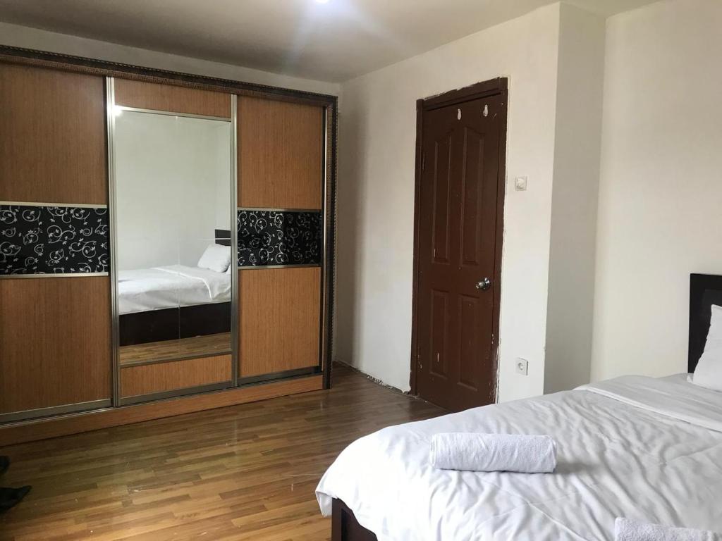 een slaapkamer met een bed en een grote spiegel bij Guest Apartment in Ganja