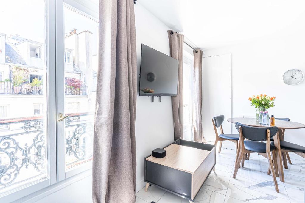 salon ze stołem i dużym oknem w obiekcie 143 - Urban Charming Flat in Center of Paris w Paryżu