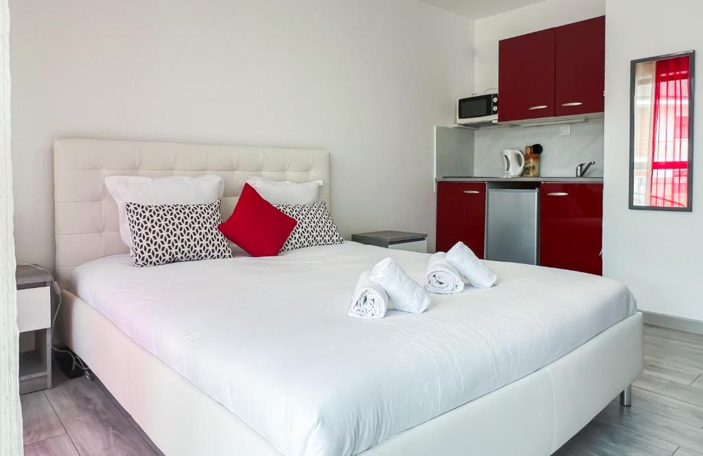 Un dormitorio con una cama blanca con almohadas. en Mango balcon 5 min de la vieille ville, en Annecy