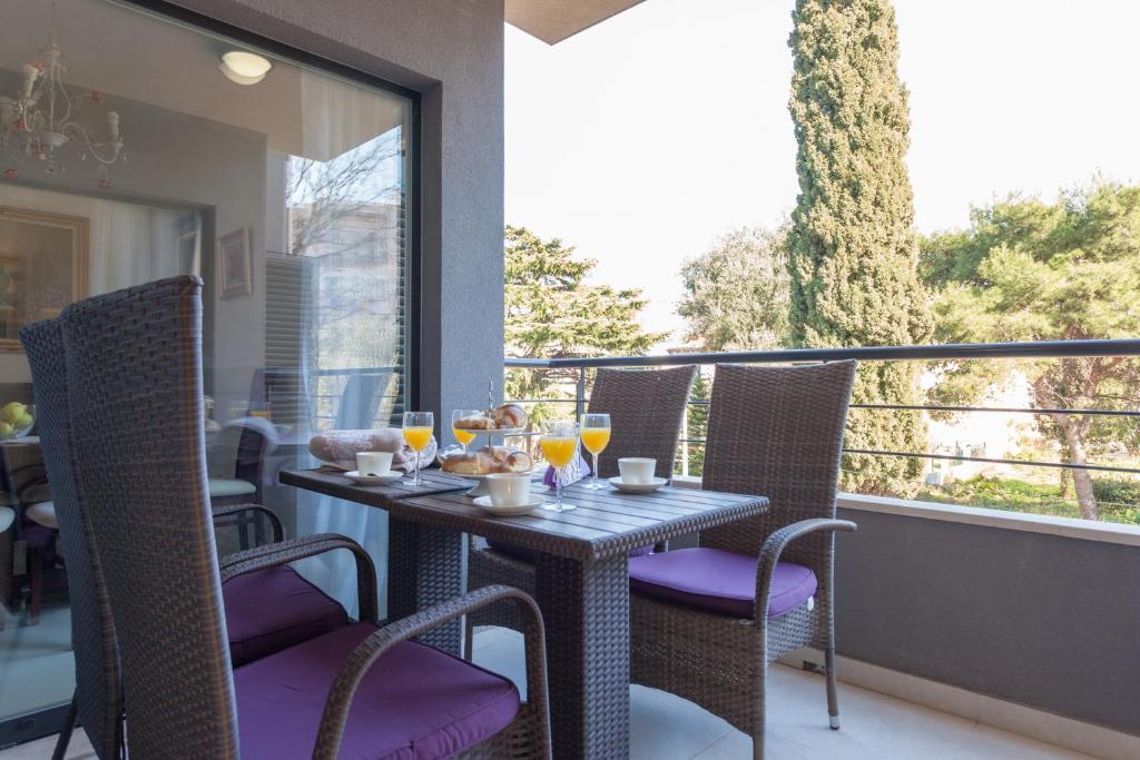 una mesa en un balcón con copas de vino en Sweet Dream Apartment, en Dubrovnik