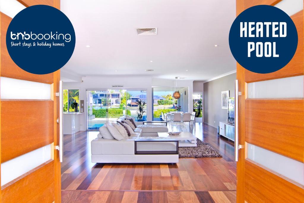 a living room with a white couch and a heated pool at SEACLUSION 5 bed waterfront, sleeps 12 in Gold Coast