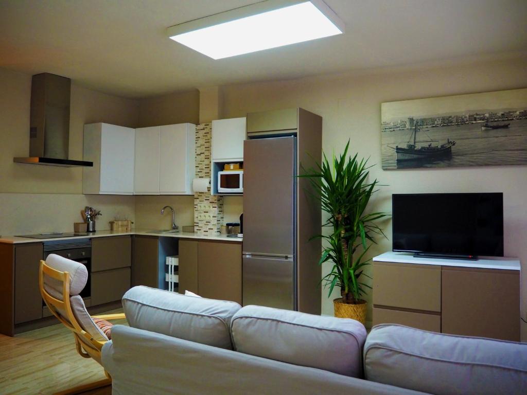 een woonkamer met een bank en een keuken bij Cal Xambu in Cambrils