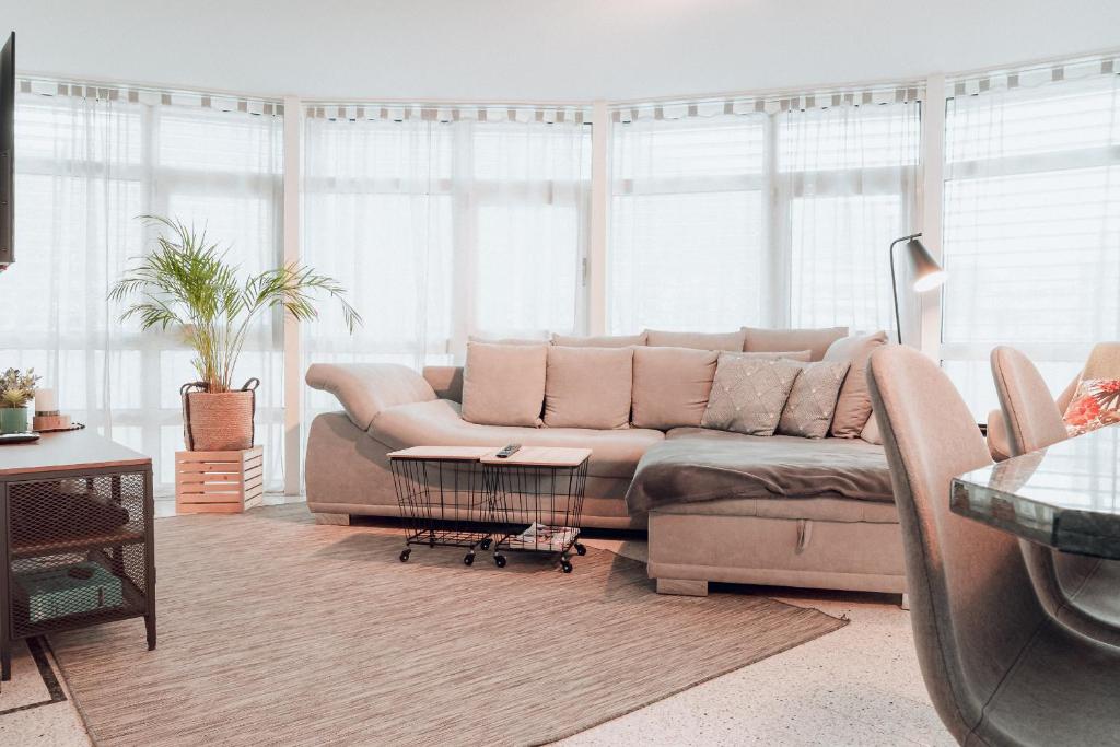 uma sala de estar com um sofá em frente a uma janela em Central Apartment - culture & nightlife in one em Visp