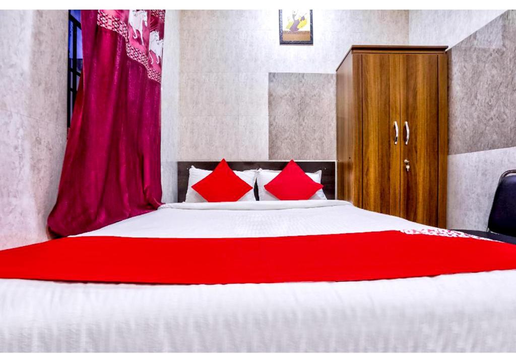 a bedroom with a large bed with red pillows at Chellam Residency in Chennai