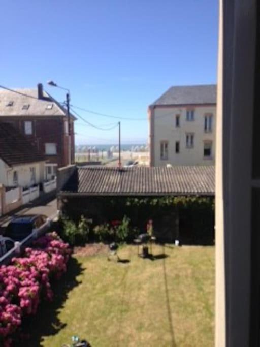 - une vue depuis la fenêtre d'une cour ornée de roses dans l'établissement Les Picantins de Cayeux sur mer, à Cayeux-sur-Mer