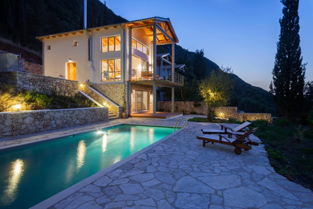 a villa with a swimming pool at night at Ionian Dream Villas in Lefkada Town