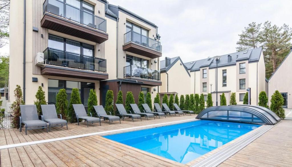 an image of a house with a swimming pool at Apartamentai Čiki puki 2 aukštas in Palanga