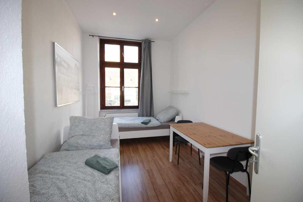 Habitación pequeña con mesa, cama y ventana en Apartment with terrace in Wuppertal, en Wuppertal