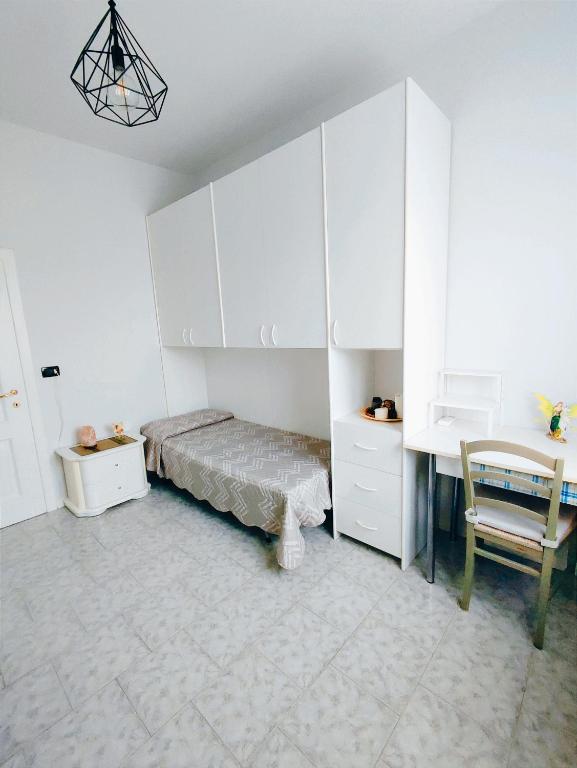 Schlafzimmer mit einem Bett, einem Schreibtisch und einem Stuhl in der Unterkunft Stanza privata a Brescia in Brescia