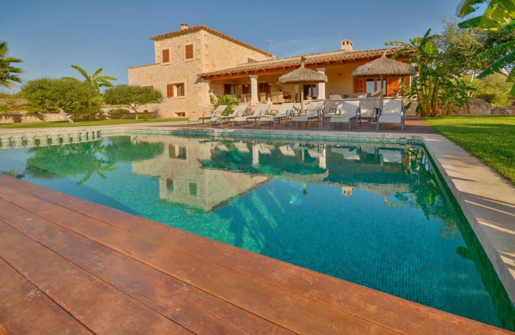 a swimming pool in front of a house at Villa Es Figueral in Campos