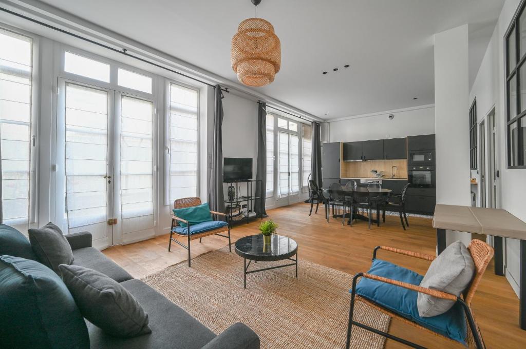 un salon avec un canapé, des chaises et une table dans l'établissement Appartement de Prestige - Grand Varenne, à Paris