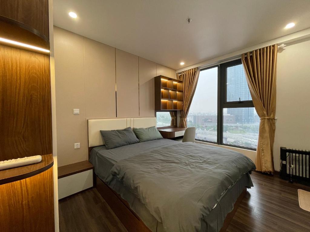 ein Schlafzimmer mit einem Bett und einem großen Fenster in der Unterkunft Homestay Honey Appartment Hải Phòng - Hoàng Huy Grand Tower in Haiphong