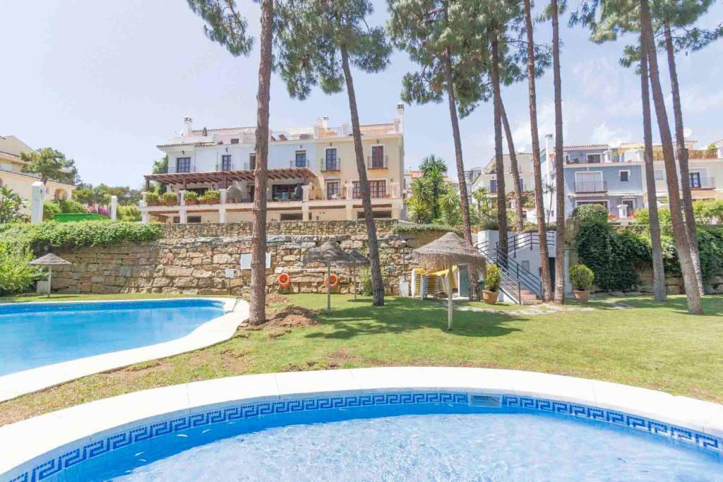 a swimming pool in front of a large building at Large townhouse Marbella golden mile in Marbella