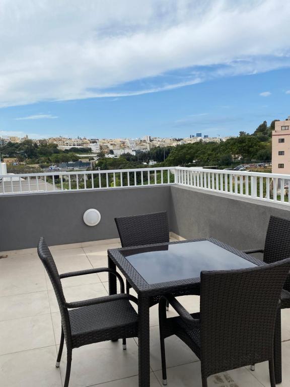 een balkon met een tafel en stoelen en uitzicht bij Msida Suites in Msida