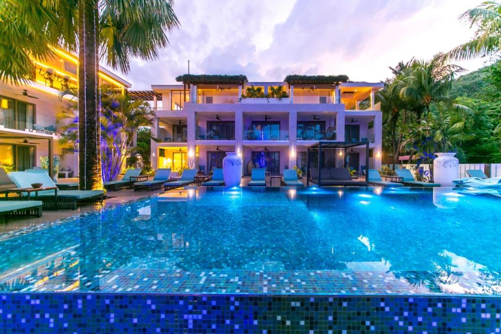 a swimming pool in front of a villa at Hotel Le Duc de Praslin in Baie Sainte Anne