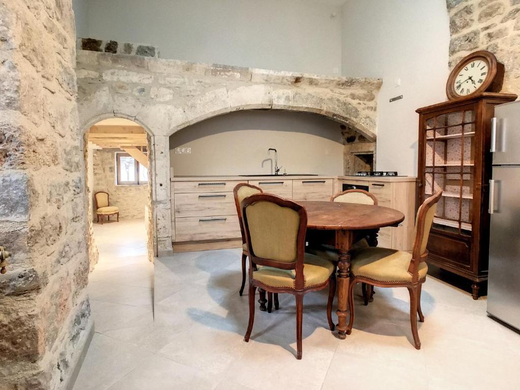 La Cresse的住宿－Gîte Le P'tit René，厨房配有桌椅和时钟