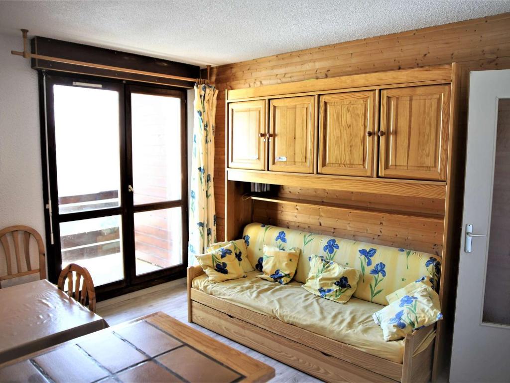 a living room with a couch and a window at Appartement 2 pièces cabine, 100m pistes, parking gratuit - FR-1-297-127 in Auris