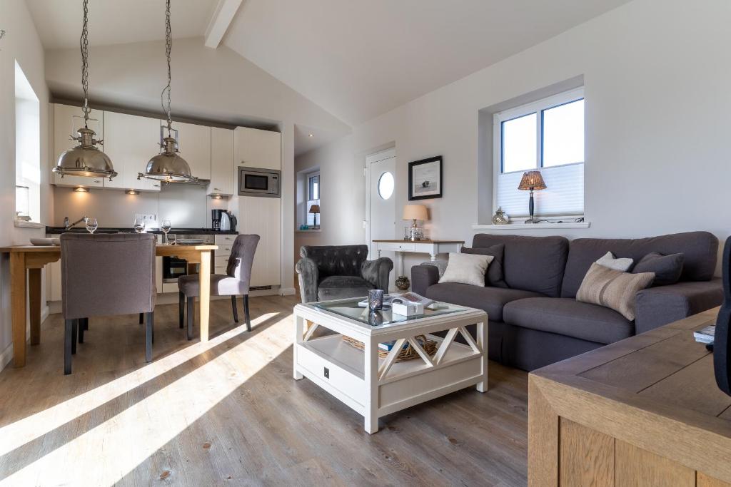 a living room with a couch and a table at Penthouse Penthouse Skipperhuset in Sankt Peter-Ording