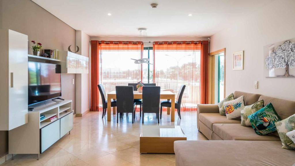 a living room with a couch and a table with chairs at Marina Vilamoura Aquamar 120 By Vilamoura Sun in Vilamoura