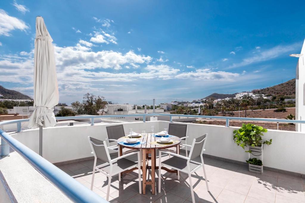 a patio with a table and chairs on a balcony at Las Hélices San José Cabo de Gata in San José