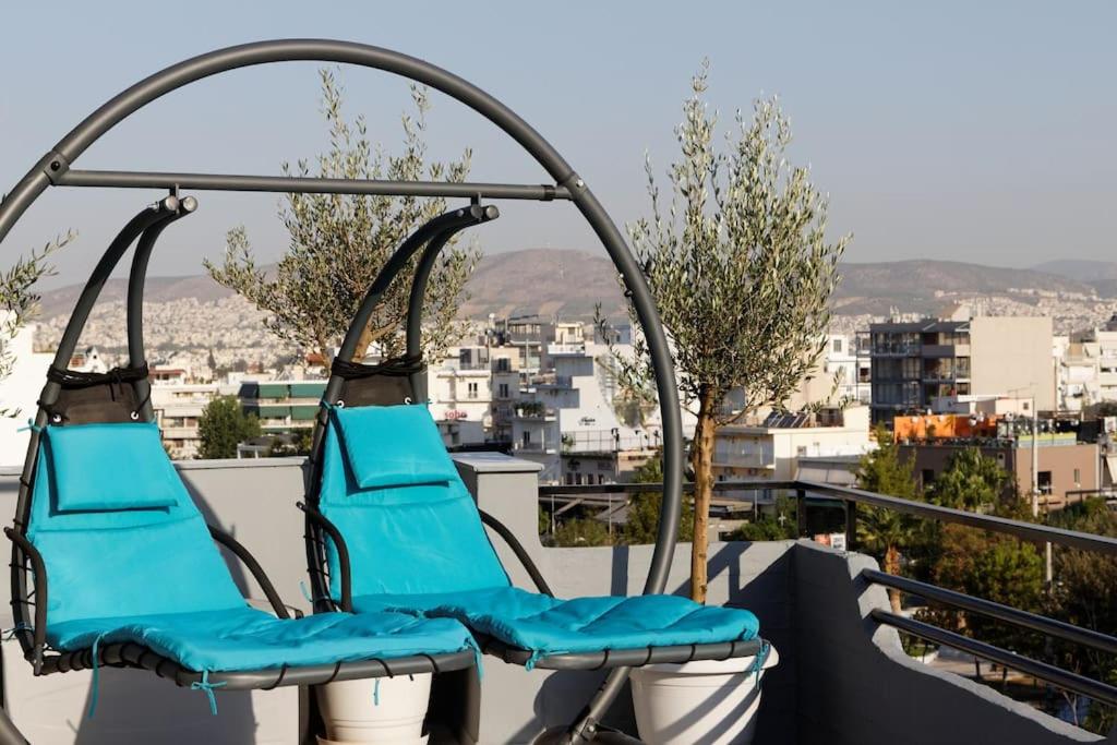 um par de cadeiras azuis na varanda em Designer loft in heart of Athens nightlife em Atenas