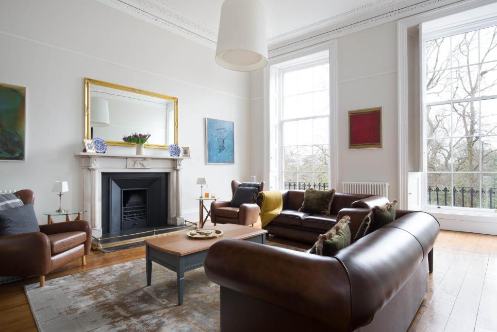 a living room with leather furniture and a fireplace at Magnificent Georgian 3-Bedroom Apartment in New Town in Edinburgh