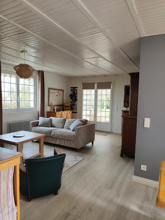 un salon avec un canapé et une table dans l'établissement Le Gîte d'Odette, à Dampierre-sous-Bouhy