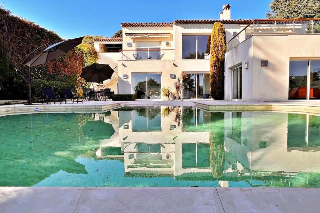 a villa with a swimming pool in front of a house at La Villa Gairaut in Nice