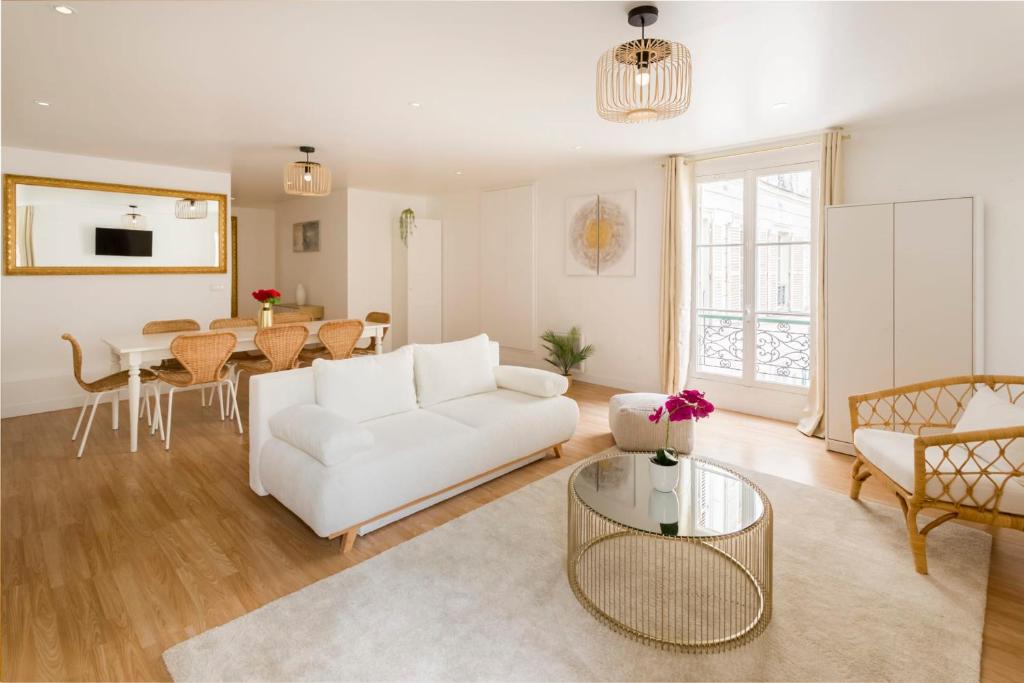 ein Wohnzimmer mit einem weißen Sofa und einem Tisch in der Unterkunft Cosy 4 Bedrooms 2 Bathr Apartment - Champs Elysées in Paris