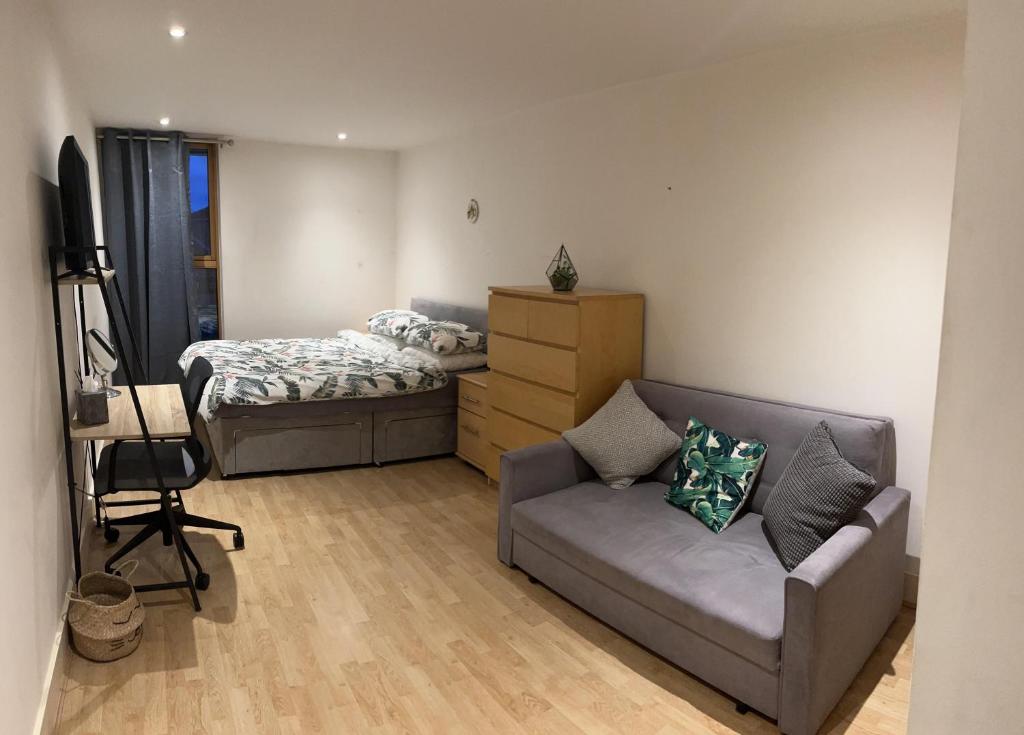 ein Wohnzimmer mit einem Sofa und einem Bett in der Unterkunft Large Room and Private Bathroom in London