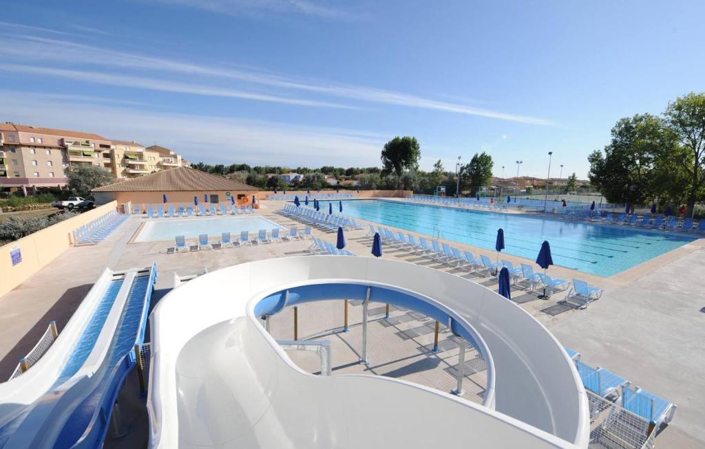 a large swimming pool with a slide in front of it at MobileHome 8 Personnes avec Clim situé au Camping l'Elysée Grau du roi Vagues Océanes By CapFun in Le Grau-du-Roi