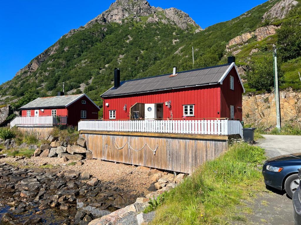 un granero rojo con una montaña en el fondo en Handkleppveien 26 - Fishermans cabin, en Straume