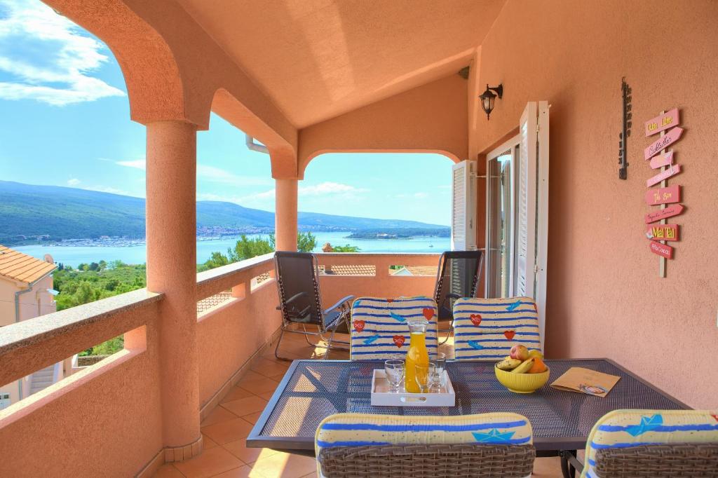 a balcony with a table and chairs and a view of the water at Apartment TOP in Kornić