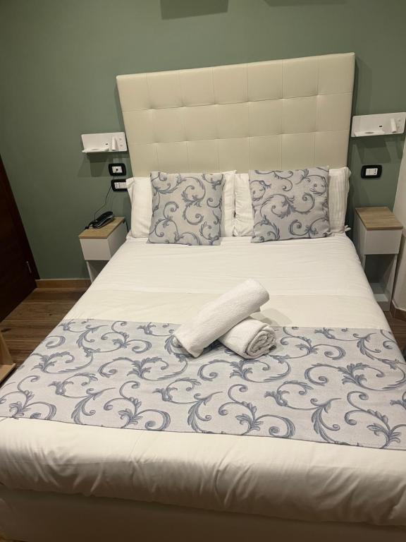 a large bed with a large headboard and a white at Hotel Veronese in Genoa