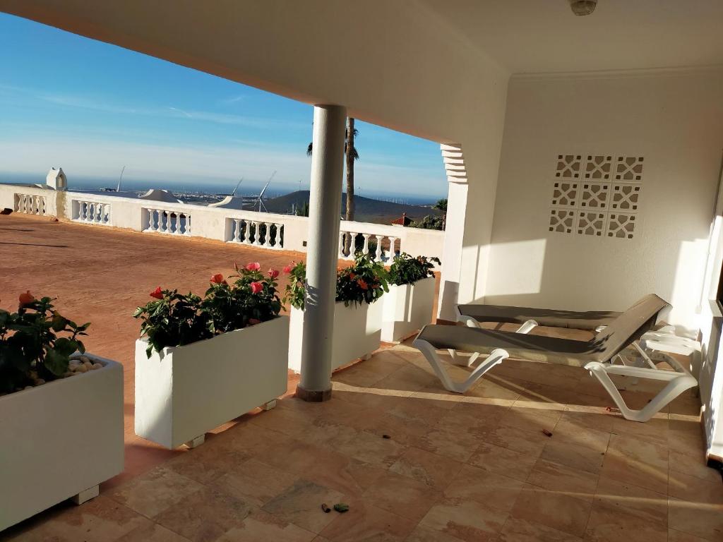 a patio with a chair and flowers on a house at Wohnung Sabina in Agüimes