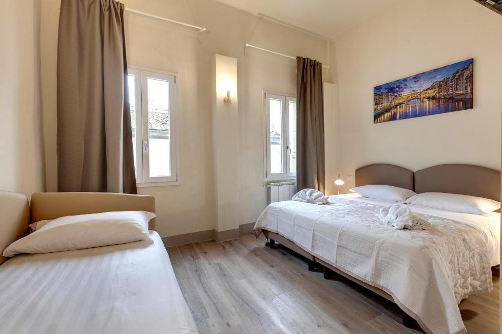 - une chambre avec 2 lits et 2 fenêtres dans l'établissement Mamo Florence - Opera - Sinfonia - Minuetto - Melody Apartments, à Florence