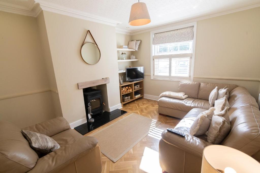 a living room with a couch and a fireplace at Mulberry Cottage - Cosy 3 Bed Cottage near Lytham Windmill in Lytham St Annes