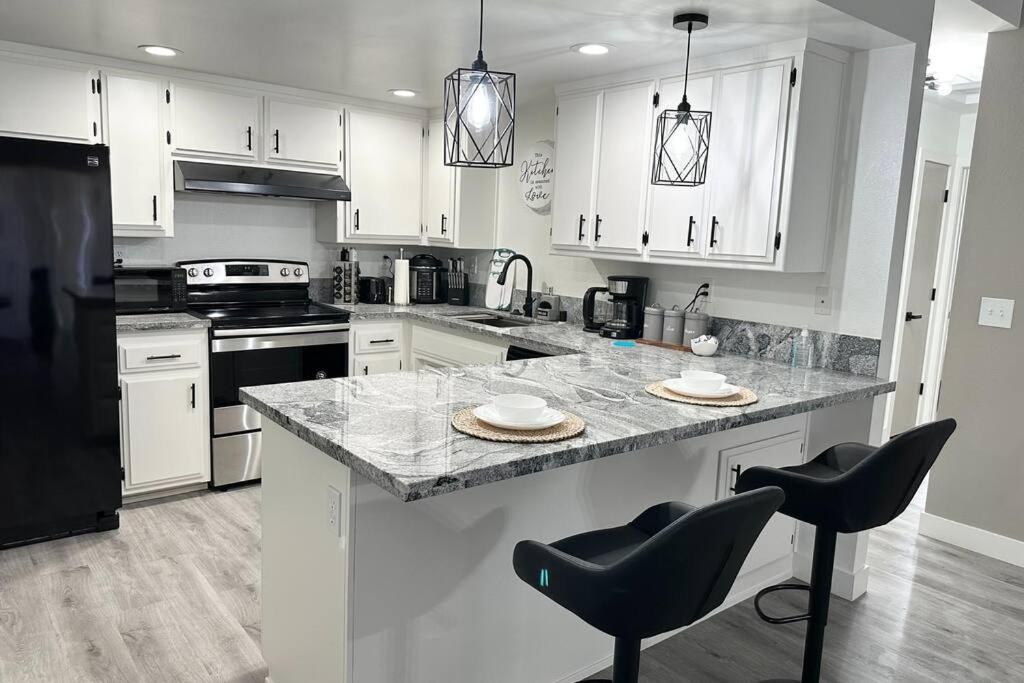a kitchen with white cabinets and a marble counter top at Cozy Getaway with King bed & 70inTV in Carmichael