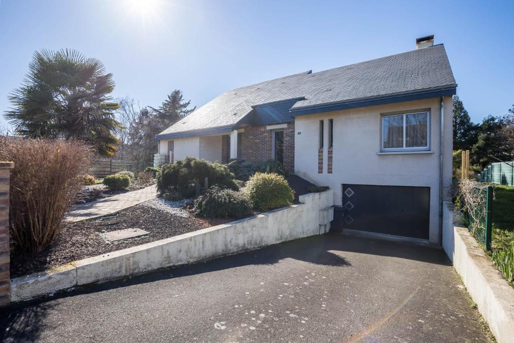 a white house with a garage and a driveway at Le Cottage - circuit Bugatti - wifi - 8pers - Rêve au Mans in Le Mans