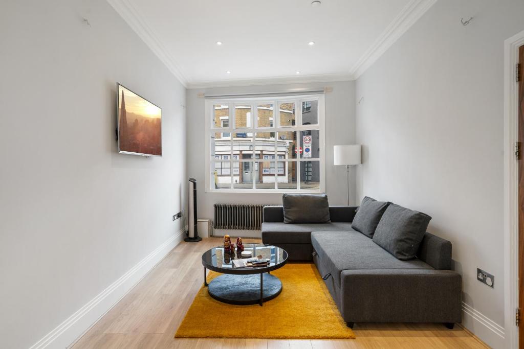 a living room with a couch and a table at Modern 4 Bedroom Townhouse with Cinema Room in the heart of London SE1 in London