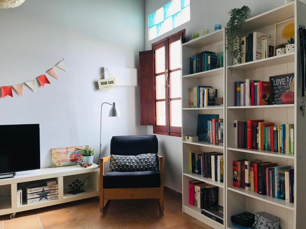 a room with a book shelf filled with books at Preciosa casa baja con aire acondicionado in Sanlúcar de Barrameda
