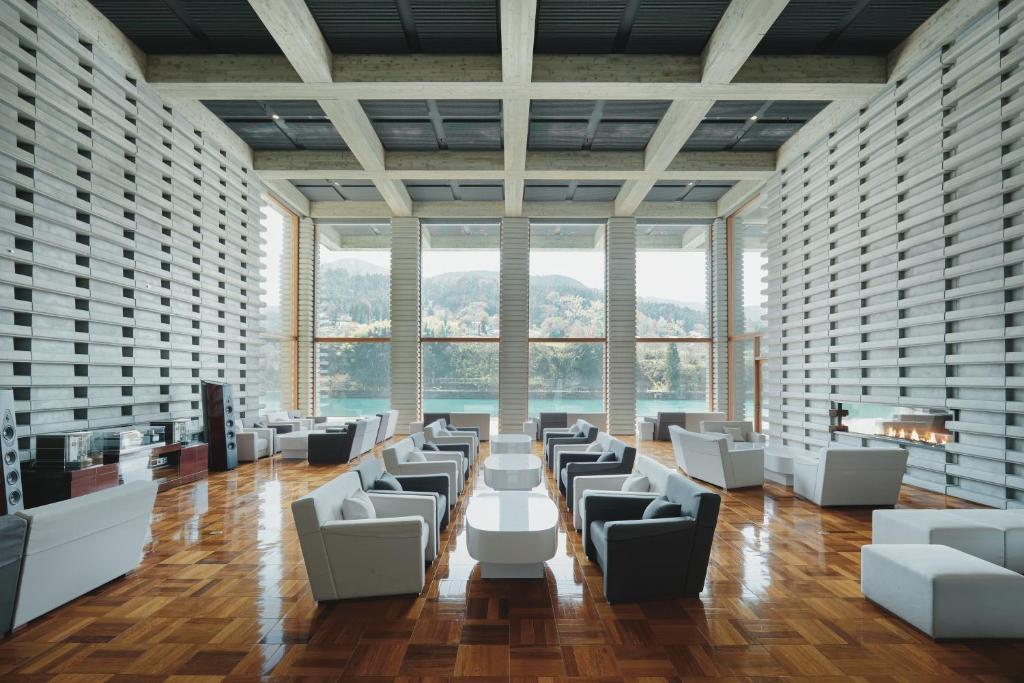 a large room with white chairs and tables and windows at River Retreat Garaku in Toyama