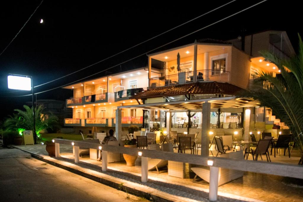 a building with a restaurant in front of it at night at Pension Delfini in Asprovalta